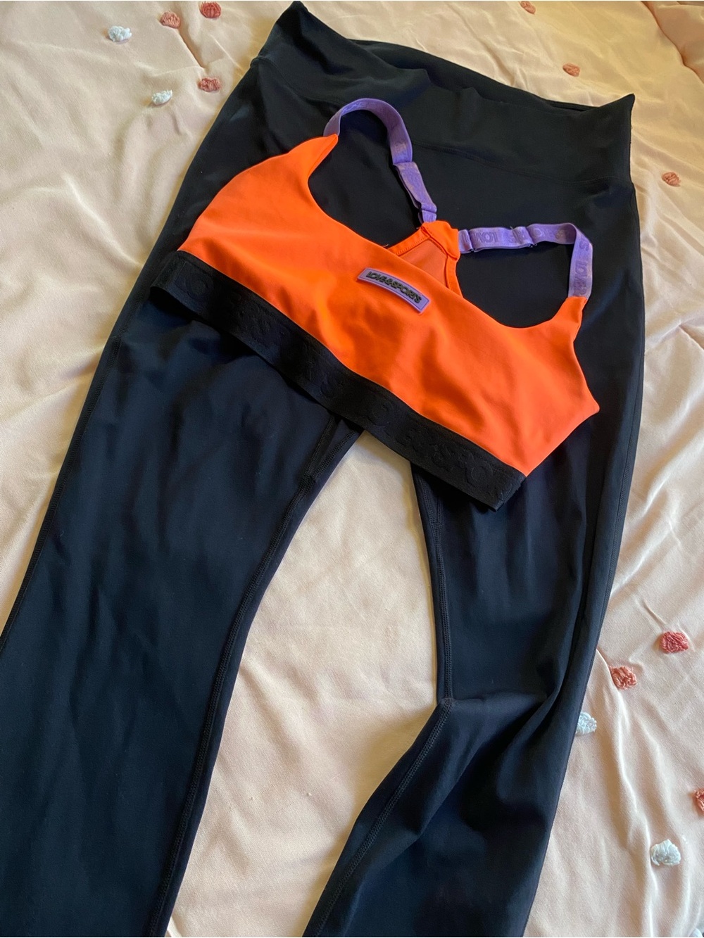 Neon Orange Sports Bra with Purple Straps and black leggings